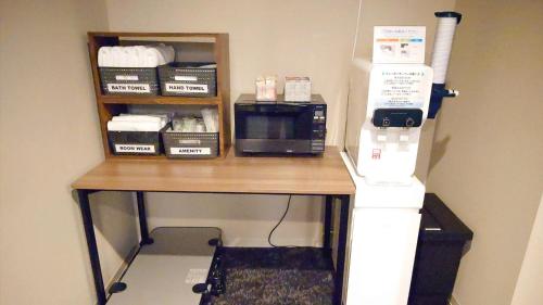 a desk with a microwave and a phone on it at Ｓｗｉｍｍｙ Ｉｎｎ Ｏｎａｇａｗａ - Vacation STAY 44059v in Onagawa