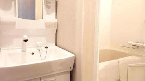 ein weißes Badezimmer mit Waschbecken und Toilette in der Unterkunft Ｓｗｉｍｍｙ Ｉｎｎ Ｏｎａｇａｗａ - Vacation STAY 44047v in Onagawa