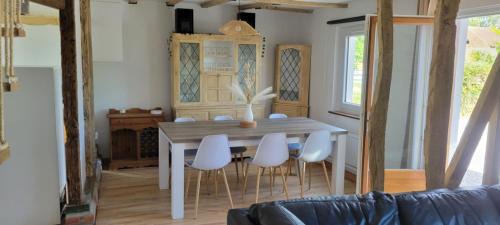 une salle à manger avec une table et des chaises blanches dans l'établissement Little House, à Zutkerque