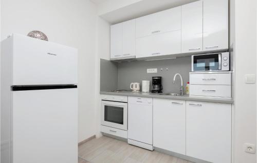 a white kitchen with white cabinets and appliances at 2 Bedroom Gorgeous Apartment In Podaca in Podaca