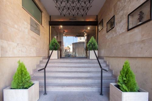 a staircase leading to a building with plants at Silken Rona Dalba in Salamanca