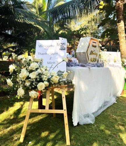 a table with a sign and flowers on the grass at HON BA LAGI BEACH RESORT in La Gi