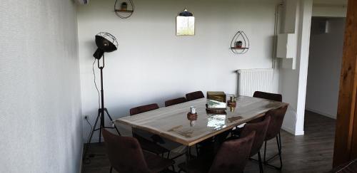 une salle à manger avec une table, des chaises et une lampe dans l'établissement La heckeliere, à La Houssière