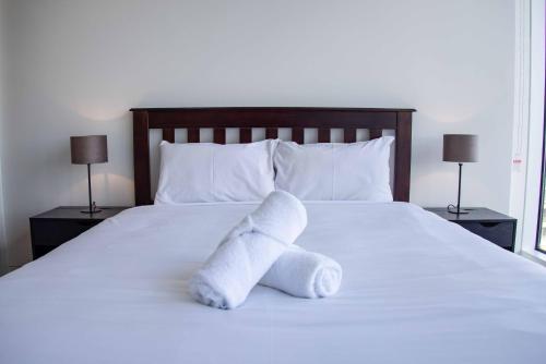 a white stuffed animal on a bed with two lamps at Starlight Concert Stay in Sydney