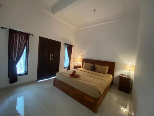 a bedroom with a bed and two lamps and a window at Npdc Comfy Hotel in Toyapakeh