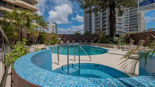 a swimming pool at a resort with a resort at Norfolk Luxury Beachfront Apartments Gold Coast in Gold Coast