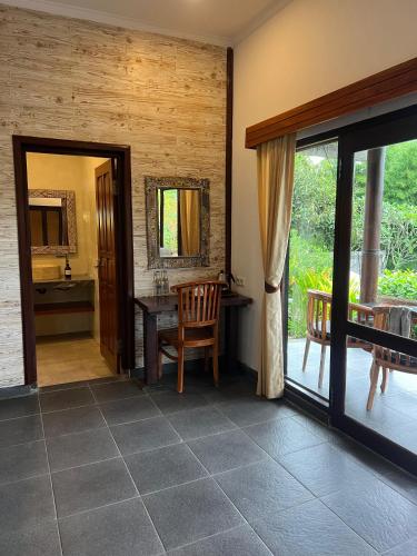 a dining room with a table and a mirror at Giri Carik in Sidemen