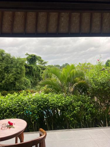 a patio with a table and a view of a forest at Giri Carik in Sidemen