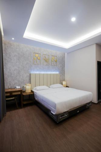 a bedroom with a large white bed and a desk at d' Omah Afi 1 in Jarakan