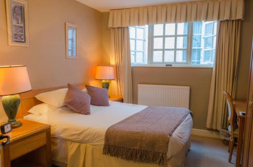 1 dormitorio con cama y ventana en The Kings Head Hotel en Abergavenny