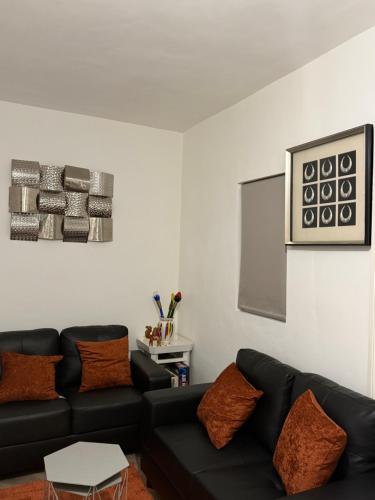 a living room with a black couch and a table at Gray Bridge Room in Northampton