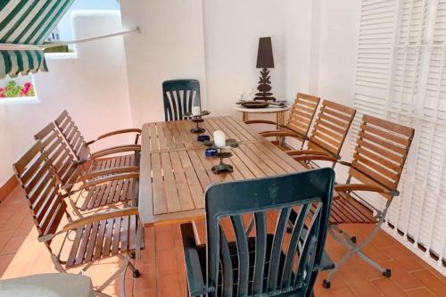 a wooden table and chairs in a room at Charming apartment in El Rompido with sea view in El Rompido