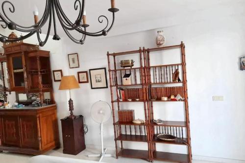a room with a book shelf and a chandelier at Charming apartment in El Rompido with sea view in El Rompido