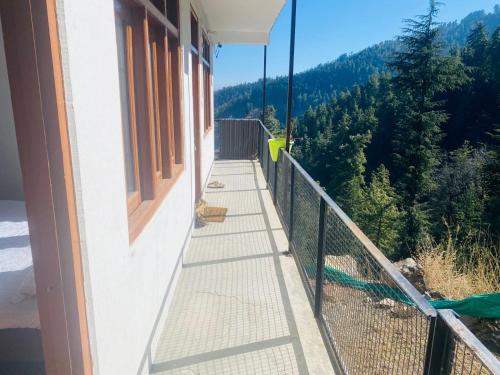 a balcony of a house with a view of the mountains at Crest of Bliss in Kūfrī