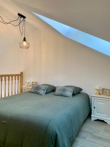 a bedroom with a bed with a blue ceiling at La petite maison in Neuvic