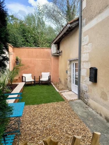 a small backyard with two chairs and a table at La petite maison in Neuvic