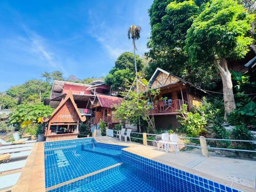 a resort swimming pool in front of a house at Phi Phi Treetop in Phi Phi Don