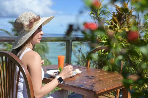 a woman sitting at a table with a plate of food at Seasalter Maldives in Hulhumale