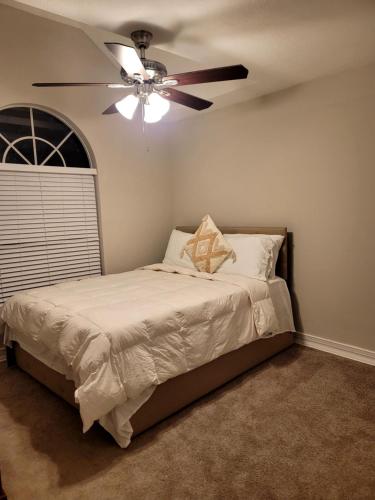 a bedroom with a bed with a ceiling fan at Elegant and Comfortable, nice house in Orlando