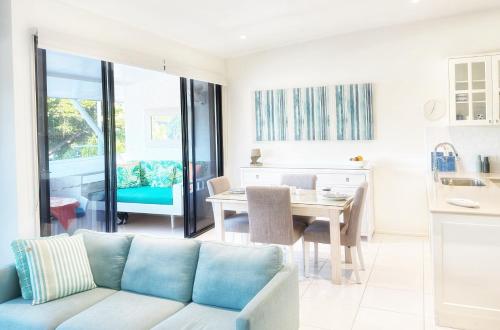 a living room with a couch and a table at Reef Luxury Apartment in Port Douglas