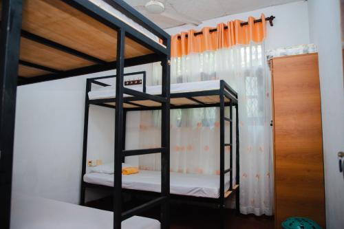 a bedroom with two bunk beds in a room at Surf Hostel Hiriketiya in Dickwella