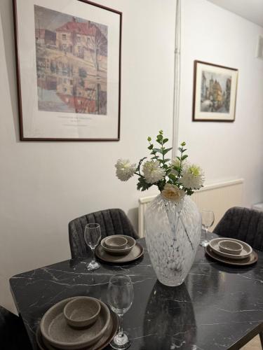 a table with plates and a vase with flowers on it at Gray Bridge Room in Northampton