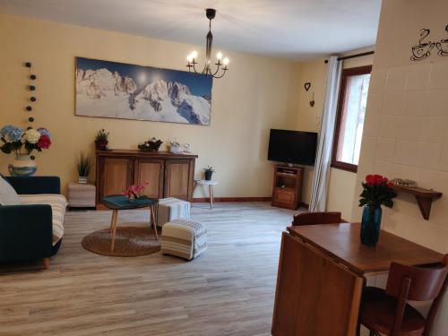 un salon avec un canapé et une télévision dans l'établissement Location MarjoRI - T2 Le Paruline, au Lauzet-Ubaye