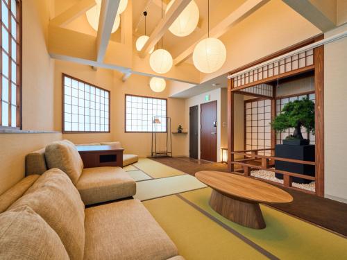 a living room with a couch and a table at KONJAKUSO Osaka Tempozan KANOH SHOHAKU Sakura Pine Tree in Osaka