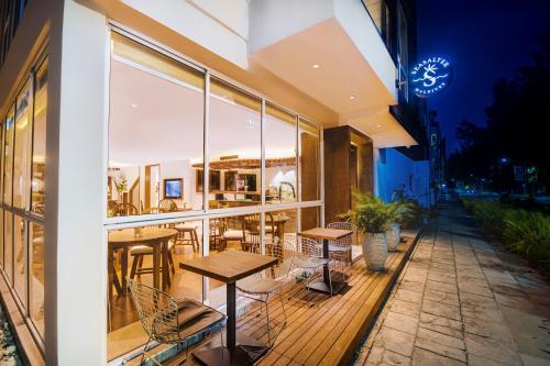a restaurant with tables and chairs on a balcony at night at Seasalter Maldives in Hulhumale