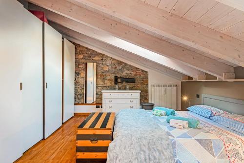 a bedroom with a large bed and a stone wall at Loft&Sun in La Spezia