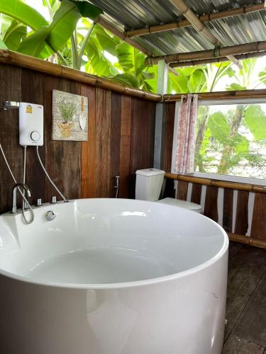 a white bath tub in a bathroom with trees at Pool Dara Resort in Hua Hin