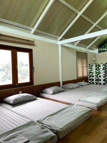 three beds in a room with two windows at Pool Dara Resort in Hua Hin