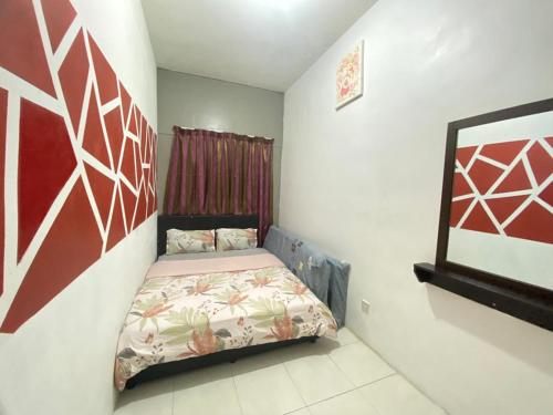 タナ・ラタにあるMUSLIM SELESA HOMESTAY CAMERONの小さなベッドルーム(ベッド1台付)が備わります。壁には絵画が飾られています。