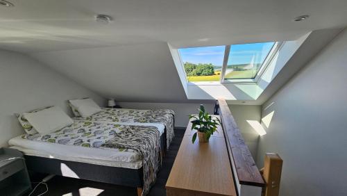 a small bedroom with a bed and a window at Attic floor with views over fields and sea in Sigtuna