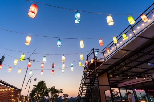 a string of lights hanging from the side of a building at One Sakon Nakhon Hotel in Ban Na Weng