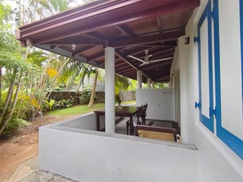 a patio with a table and chairs under a pergola at White Villa - Homestay in Tangalle