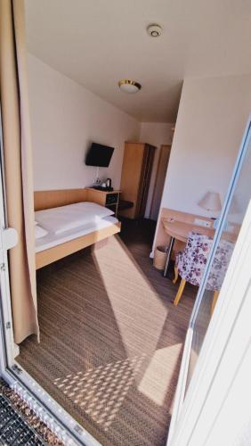 a small room with a bed and a desk at Hotel Garni Superior in Metzingen
