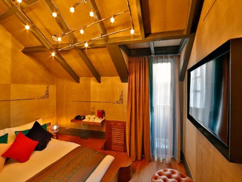 a room with a bed and a tv at Sanat Boutique Hotel Pera in Istanbul
