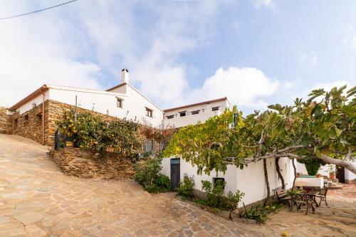 a white house with a stone wall at Casa Rural Albaida in Laroya