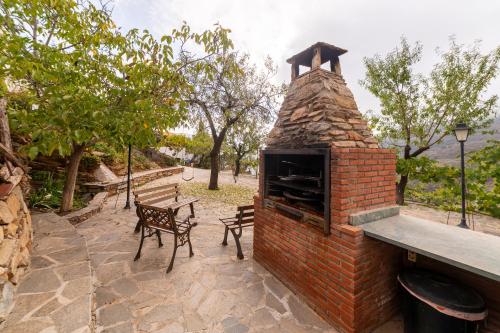 a brick oven with a table and a bench at Casa Rural Albaida in Laroya