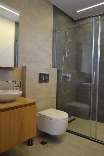 Un baño con ducha, inodoro y lavabo. en Villam çeşme, en Cesme