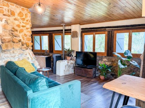 a living room with a blue couch and a tv at Casas Rio Verde in Cheleiros