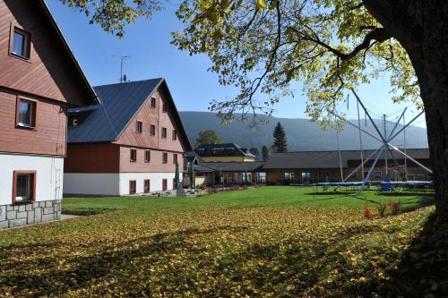 a large red barn with a tree in the foreground at Rodinný penzion Skiland in Ostružná