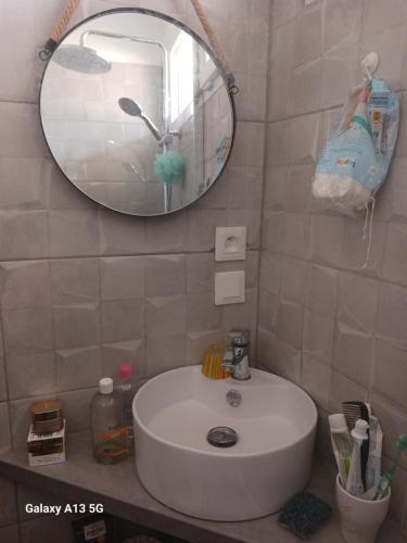 une salle de bain avec un lavabo blanc et un miroir dans l'établissement Maison a etage, au Le Verdon-sur-Mer