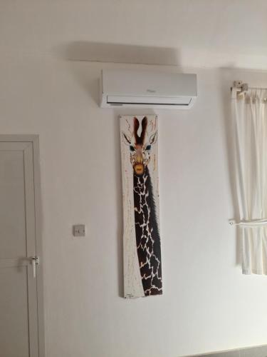a painting of a giraffe hanging on a wall at Princess of Zanzibar in Michamvi
