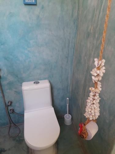 a bathroom with a white toilet and a plant at Princess of Zanzibar in Michamvi