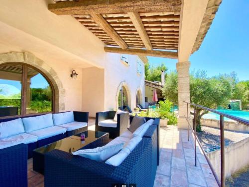 un patio extérieur avec des canapés et une piscine dans l'établissement Mas provençal, à Poussan