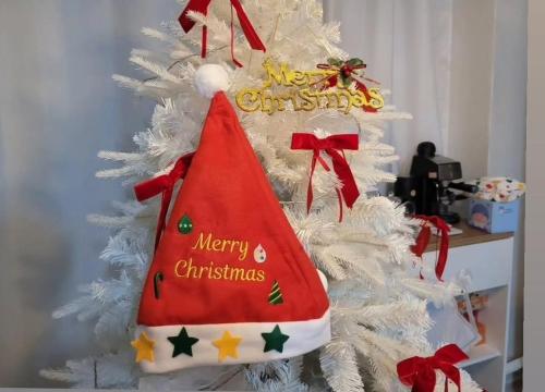 a white christmas tree with a red hat on it at Anime House in Daejeon