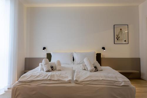 a large white bed with white sheets and pillows at Residence Canova in Spinea