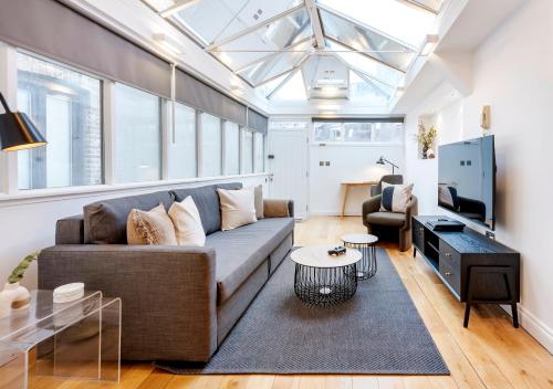 a living room with a couch and a tv at 2 Bedr, 3 Beds, 2 Bath Covent Garden 3-min subway in London